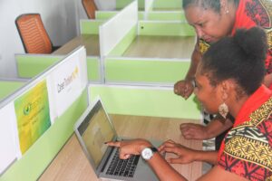 CTPNG CEO, Ellenor Iutiko looks on as colleague, Olivia Peni, points at macbook screen.
