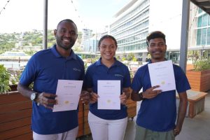 Monty Trei, Kristina Kovea, and Gabriel Isikiel proudly display their certificates of completion from SNS Tech's inaugural internship program, now celebrating their new roles as full-time employees.